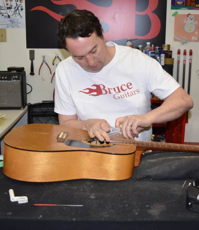 Bruce repairing guitar at workbench